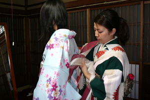 The clerk dresses the kimono to you.